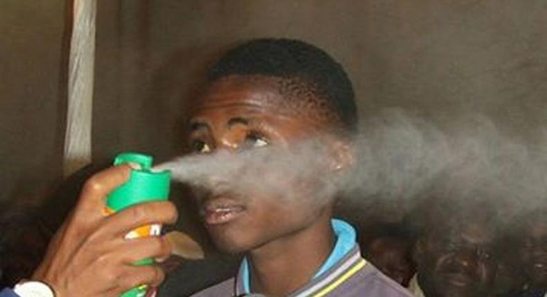 Pastor Lesotho spraying boy with doom