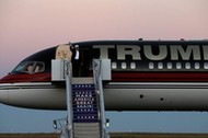 Republican presidential nominee Donald Trump waves as he walks off his plane at a campaign rally in 