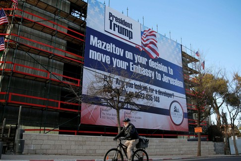 People walk past a giant banner on a building congratulating U.S. President-elect Donald Trump in Je