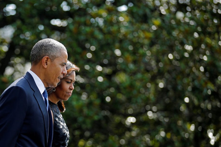 U.S. President Barack Obama walks on the South Lawn of the White House accompanied by first lady Michelle Obama during their departure to Dallas, Texas, in Washington