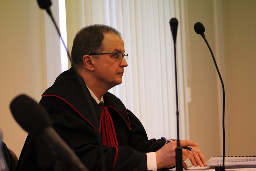Prokurator Piotr Krupiński przysłuchujący się zastrzeżeniom do jego ustaleń w śledztwie