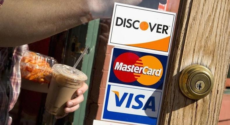 A coffee shop displays signs for Visa, MasterCard and Discover in WashingtonThomson Reuters