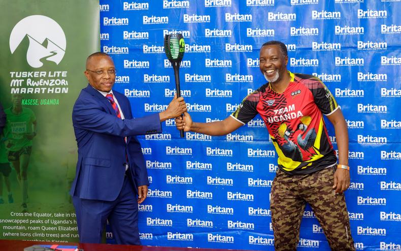 Amos Wekesa hands over the marathon torch to Allan Mafabi, the Britam CEO