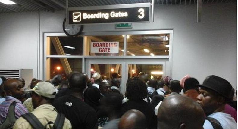 Passengers at the Nnamdi Azikwe International Airport, who were scheduled to travel to Ibadan by Arik Air but were left stranded for hours, block boarding gate at Abuja Airport January 30, 2015, in protest.