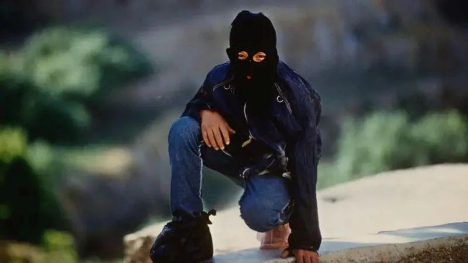 Palestinski borac sa maskom da bi sakrio svoj identitet, na slici patrolira selom na okupiranoj Zapadnoj obali u junu 1989. godine | Foto: Getty Images