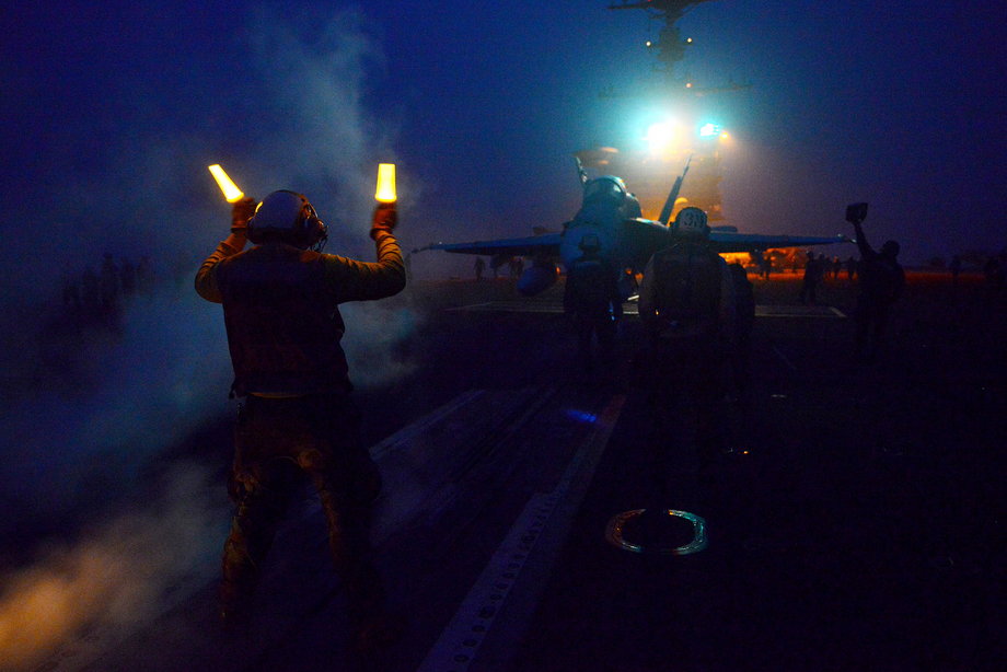 Aviation Boatswain's Mate 3rd Class Kevin Williams directs an F/A-18C Hornet from the Warhawks of Strike Fighter Squadron 97 on the flight deck of the aircraft carrier USS John C. Stennis.