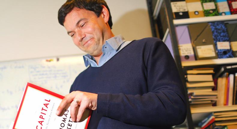 French economist and academic Thomas Piketty, poses in his book-lined office at the French School for Advanced Studies in the Social Sciences (EHESS), in Paris May 12, 2014.