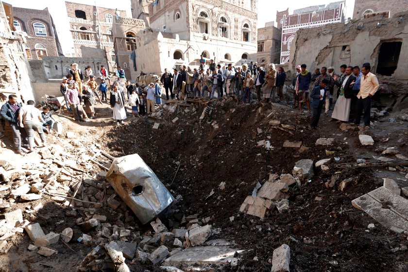 People gather at the site of an air strike in Sanaa, Yemen