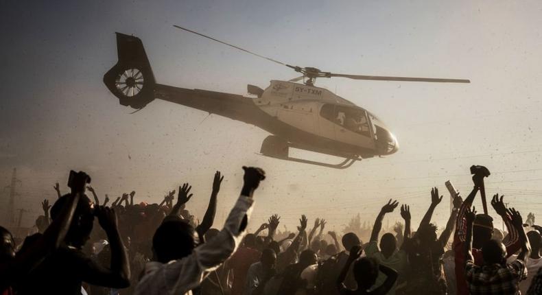 Supporters of Raila Odinga wave as he departs in a helicopter after addressing a rally held by his coalition party The National Super Alliance (NASA) in Kisumu on August 3, 2017. (Photo by FREDRIK LERNERYD/AFP via Getty Images)