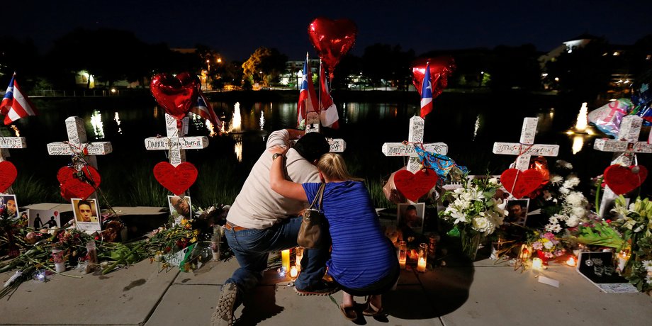 Jose Louis Morales with a woman on Monday at his brother Edward Sotomayor Jr.'s cross, which was part of a makeshift memorial for the victims of the Pulse nightclub shootings in Orlando, Florida.