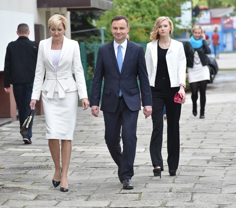 Naszym zdaniem oni wyglądali podczas dzisiejszego głosowania zdecydowanie najbardziej elegancko. Małżonka kandydata PiS-u po raz kolejny postawiła na na idealnie dopasowany do figury komplet - marynarkę z fantazyjną ozdobą i spódnicę ołówkową - wszystko w odcieniach bieli i ecru, a do tego czarne dodatki. To był naprawdę udany zestaw!