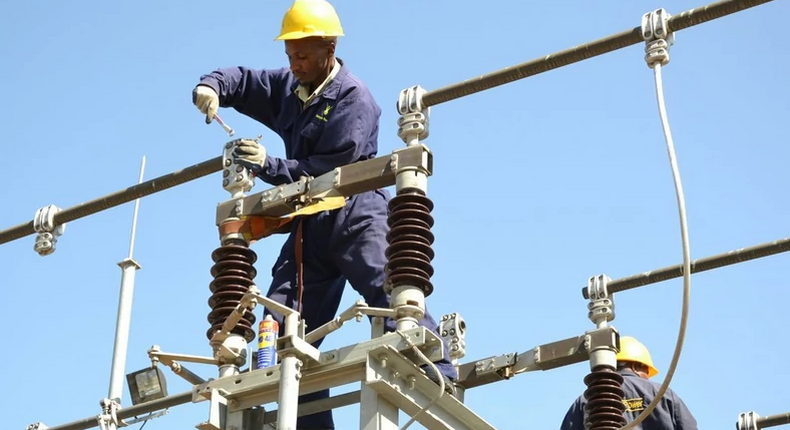 A Kenya Power employee working on a power line