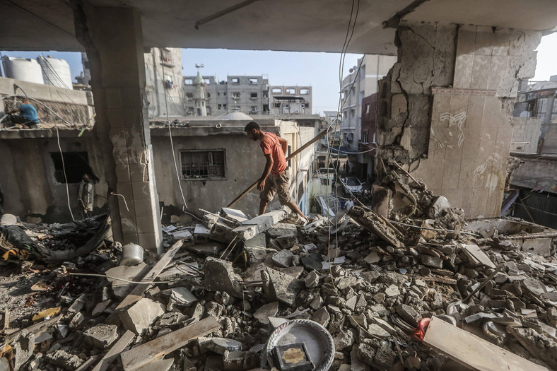 Palestyńczyk sprawdza w Chan Junus zniszczony dom miejscowego dziennikarza telewizyjnego Muhammada Abu Hataba, który zginął wraz z członkami rodziny podczas izraelskiego bombardowania miejscowości w południowej Strefie Gazy