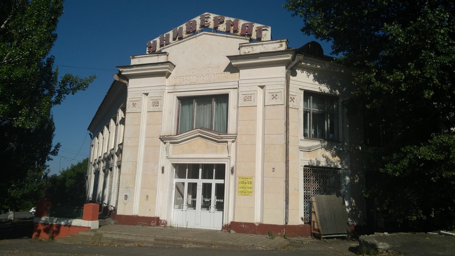 <br></br>
Pamiętający czasy sowieckie sklep spożywczo-przemysłowy w Lisiczańsku. Przed drzwiami wciąż wiszą godziny otwarcia. Drzwi były jednak zamknięte. Przeżywający swoje chwile świetności dawno temu szyld na szczycie budynku powoli rdzewieje, a o dawnych czasach przypominają wyrzeźbione na fasadzie budynku skrzyżowane narzędzia kopalniane (u nas te „młotki” to pyrlik i żelosko). Lisiczańsk jest w końcu miastem górniczym.
<br></br>