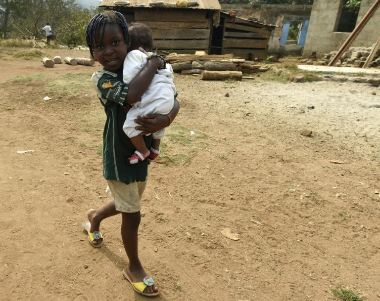 Boy walks with a baby in a local community in Rivers (AFP)