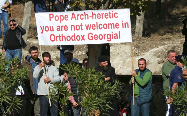 People hold a banner against the visit of Pope Francis to Georgia and Azerbaijan in Tblisi