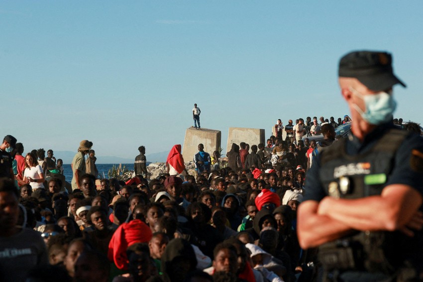 Stotine migranata na plaži u Seuti, nadgleda ih španski policajac | Foto: REUTERS/Violeta Santos Moura