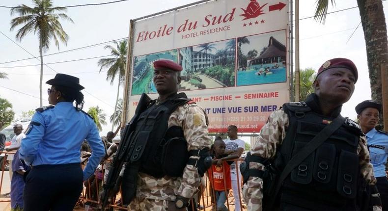 Soldiers stand near The Hotel Etoile du Sud on March 13, 2016, in Grand Bassam, during a commemoration ceremony for the first anniversary of the 2016 Grand Bassam beach terrorist attack, resulting in the death of 19 people