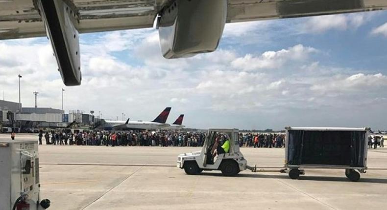 Passengers gather on the tarmac of the Fort Lauderdale-Hollywood airport in Florida after a gunman opened fire, killing five people and injuring 8 on January 06, 2017