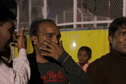 Men mourn the death of their relatives after a blast outside a public park in Lahore, Pakistan