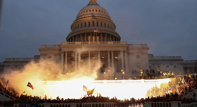 An explosion caused by a police munition is seen while supporters of President Donald Trump gather in front of the US Capitol Building in Washington DC on January 6, 2021.