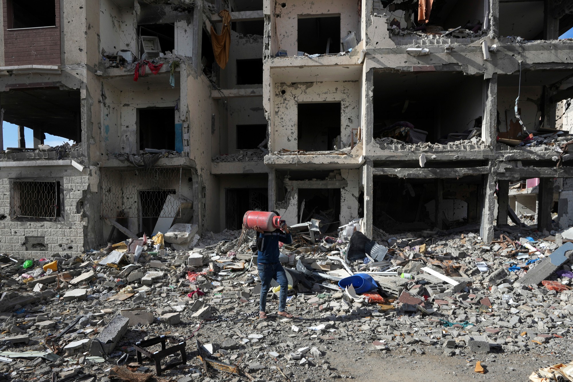 Palestínčan zbiera svoje veci pri zničenom dome po izraelskom bombardovaní na juhovýchode Gazy, v pásme Gazy 28. novembra 2023 počas piateho dňa prímeria medzi palestínskym radikálnym hnutím Hamas a Izraelom.