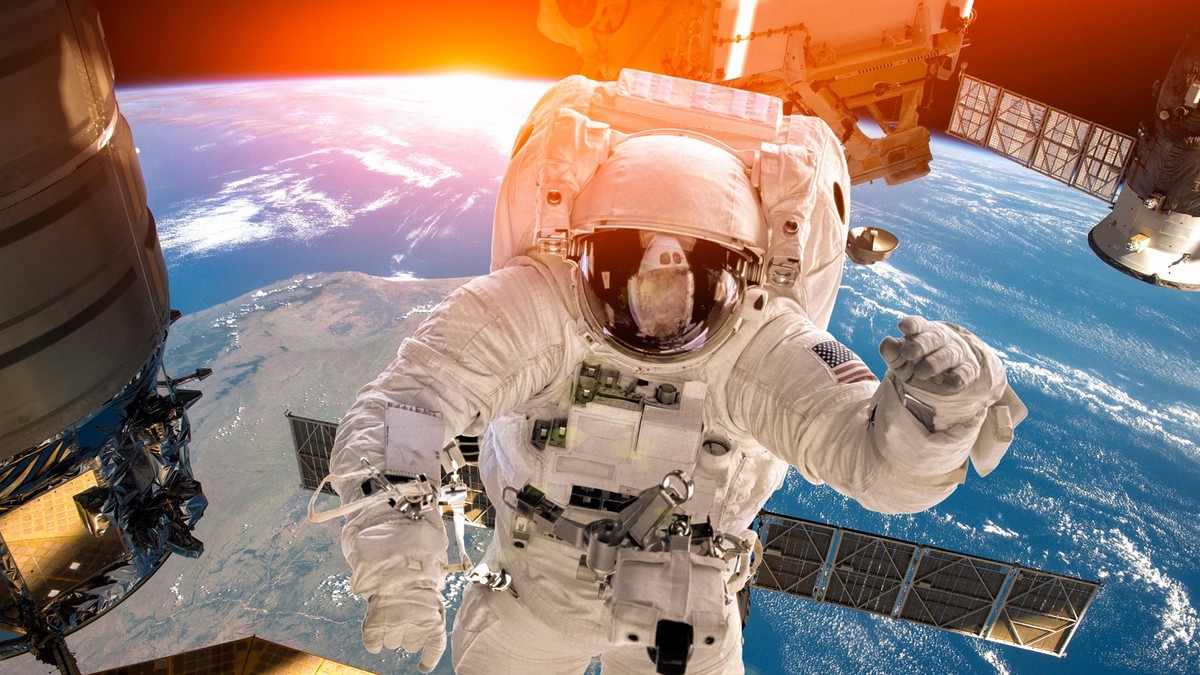 Ilustracija: Međunarodna svemirska stanica i astronaut u svemiru iznad planete Zemlje