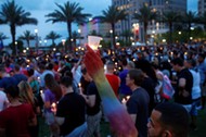 Man raises a candle during a vigil in memory of victims one day after a mass shooting in Orlando, Fl