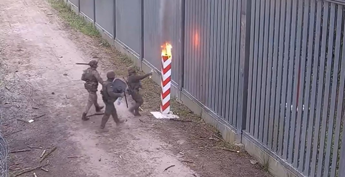 Funkcjonariusze Straży Granicznej gaszą podpalony ze strony białoruskiej słup graniczny