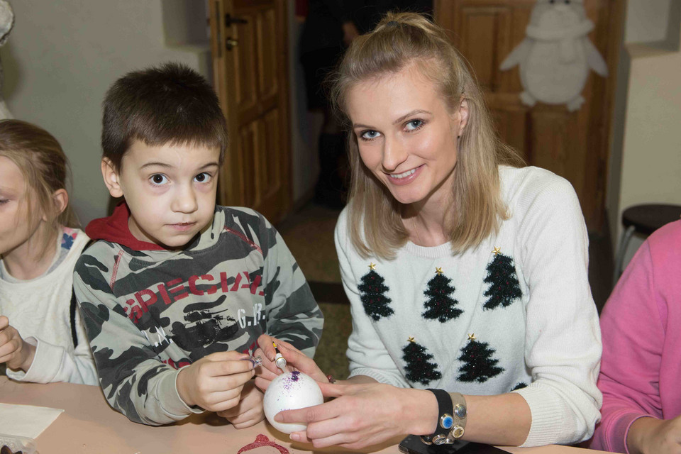 Anna Piszczałka maluje bombki na przedświątecznym spotkaniu z dziećmi