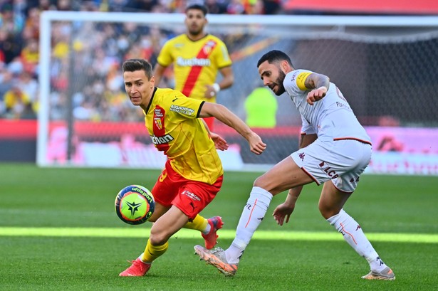 Piłkarz RC Lens Przemysław Frankowski (L) w starciu z zawodnikiem Metz Dylanem Bronnem (P)