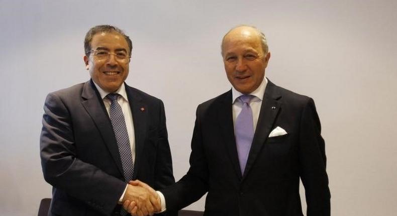 Tunisia's Foreign Minister Mongi Hamdi (L) shakes hands with his French counterpart Laurent Fabius at the Tunis-Carthage International Airport in Tunis September 7, 2014. REUTERS/Zoubeir Souissi
