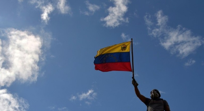 An opposition demonstrator holds a national flag during the Towards Victory protest against the government of Nicolas Maduro, in Caracas on June 10, 2017