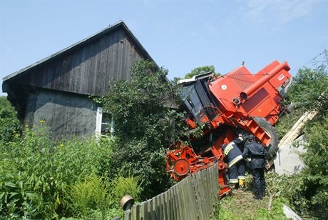 20.07.2007 Wystepa kolo Kielce (swietokrzyskie) - kombajn zjezdzal ze stromego wzniesienia, nagle wyskloczyl bieg i kombajnista nie byl juz w stanie zatrzymac maszyny. Stoczyl sie z wysokiego nasypu i uderzyl w dom.Fot. Dariusz Gacek