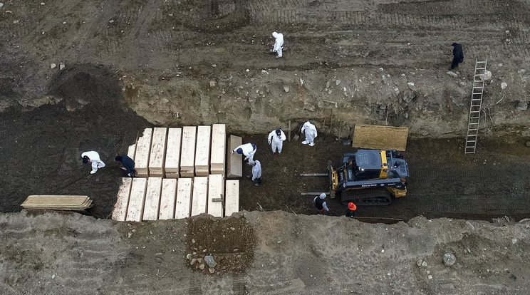 Az új koronavírus okozta betegségben elhunytak koporsóit temetik árokszerű, hatalmas sírba a New York-i Bonx negyedhez tartozó Hart-szigeten 2020. április 9-én. / Fotó: MTI/AP/John Minchillo