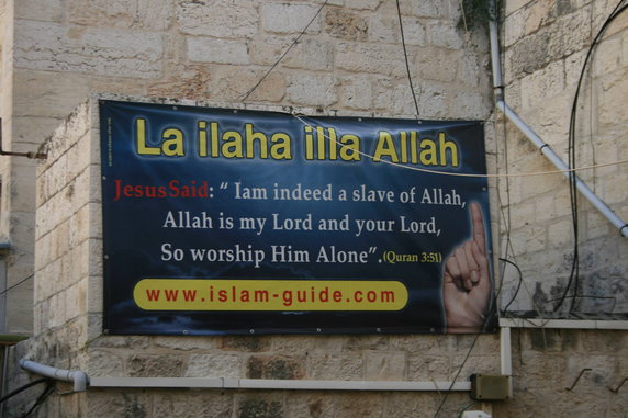 Baner na ścianie koło wejścia do Bazyliki Grobu Pańskiego w Jerozolimie (zdjęcie z 2013 roku)