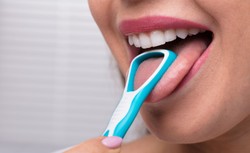 Język wiele "mówi" o naszym zdrowiu. Co żyje na języku i czy warto go skrobać?