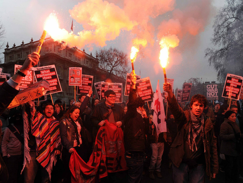 Londyn: Studenci palą flary przed Downing Street podczas protestu przeciwko podyżkom opłat za studia. Fot. PAP/EPA/FACUNDO ARRIZABALAGA
