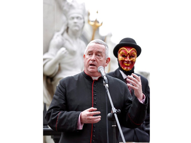 Dziekan londyńskiej katedry św. Pawła przemawia do protestujących z ruchu „Okupuj londyńską giełdę ”. Za nim, w masce, jeden z protestujących, którzy rozbili obóz naprzeciw katedry św. Pawła. Setki manifestantów podjęło antykapitalistyczny protest w londyńskim City