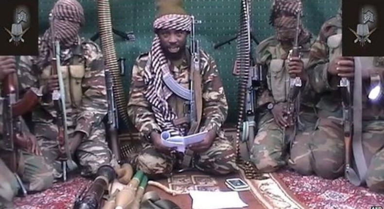 Boko Haram leader Abubakar Shekau [with a book], flanked by his men