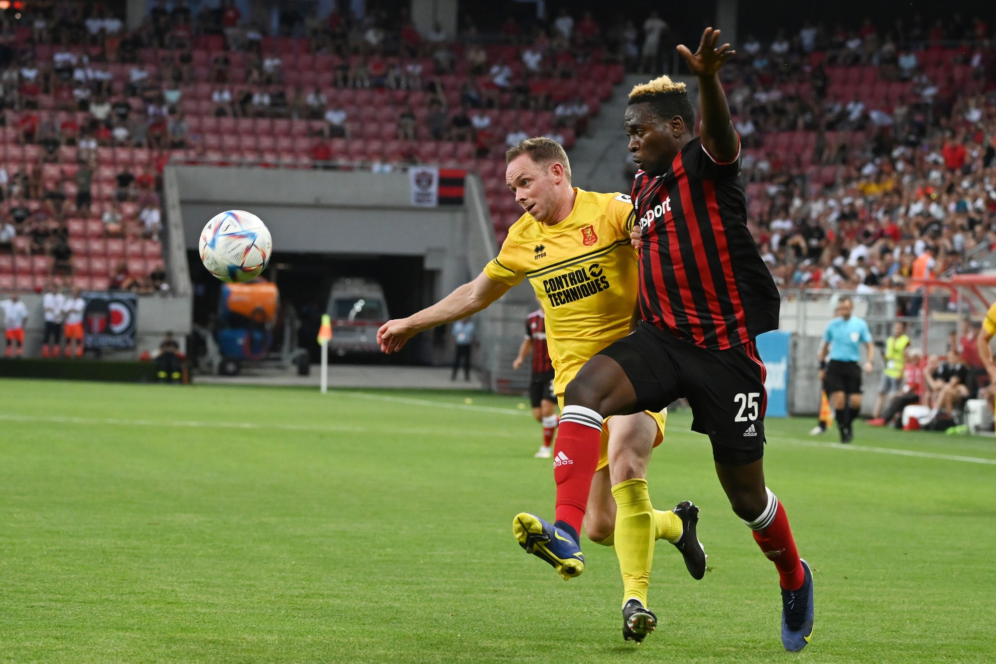 Hráč Spartaka Bamidele Yusuf a kapitán Newtownu Craig Williams bojujú o loptu.