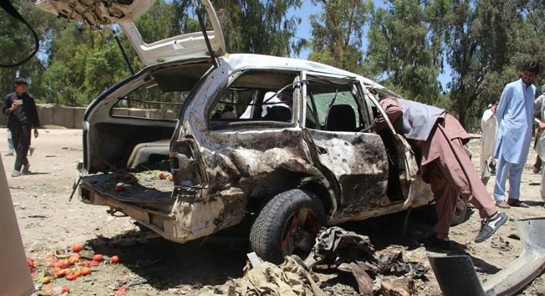 Afghan residents gather at the scene of a suicide car bomb that targeted a CIA-funded pro-government militia force at a public bus station in Khost province on May 27, 2017