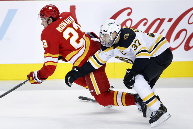 Hokeista Calgary Flames Sean Monahan (L) w starciu z zawodnikiem Boston Bruins Patrice'em Bergeronem (P)