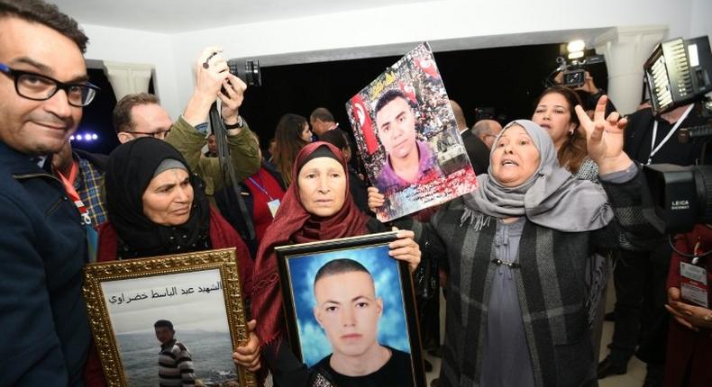 Mothers of torture victims under Tunisia's authoritarian rulers carry their sons' portraits at a hearing of The Truth and Dignity Commission (IVD) in Tunis