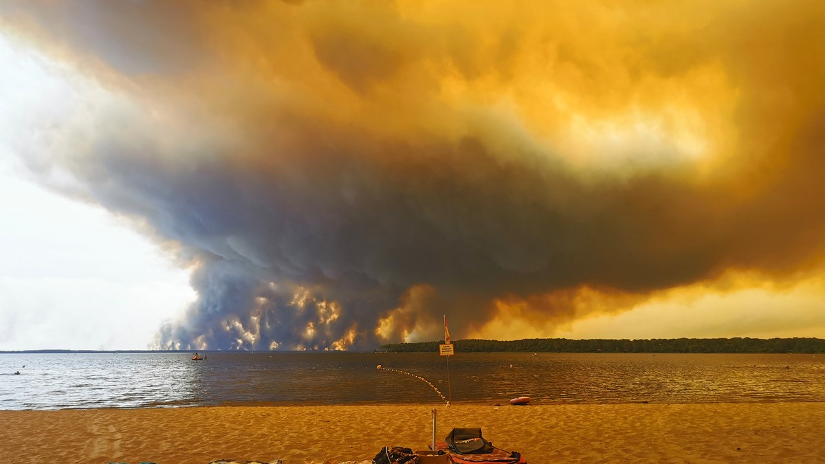 Posetioci plaže odmaraju se na plaži Mučik na obali jezera Lakano u Lakanou, na jugozapadu Francuske, dok požar besni u Žirondi, 24. jul 2026.