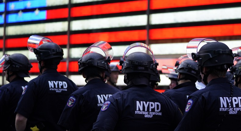 NYPD police officers watch demonstrators in Times Square on June 1, 2020, during a Black Lives Matter protest. - New York's mayor Bill de Blasio today declared a city curfew from 11:00 pm to 5:00 am, as sometimes violent anti-racism protests roil communities nationwide. Saying that we support peaceful protest, De Blasio tweeted he had made the decision in consultation with the state's governor Andrew Cuomo, following the lead of many large US cities that instituted curfews in a bid to clamp down on violence and looting
