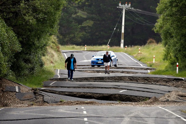 Local residents Chris and Viv Young look at damage caused by an earthquake along State Highway One, 