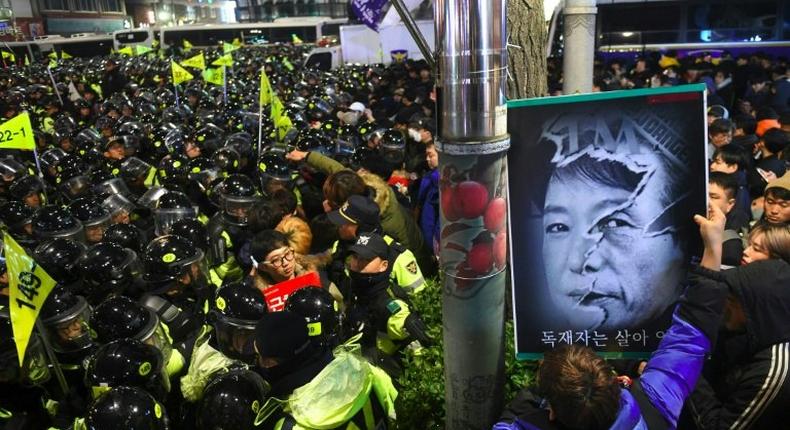 Riot police and protesters engage in a shoving match as the protesters attempt to march toward the presidential Blue House during an anti-government rally in Seoul