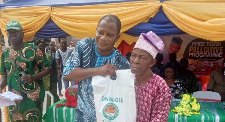 Mr Olusegun Onilude, the Chairman, Badagry Local Government, presenting free food items to Mr Matthew Avoseh, a retired head teacher, during the distribution of free food items to people in Badagry [NAN]