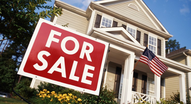 House with American flag and 'for sale' sign, low angle view - stock photoPhillip Spears/ Getty Images